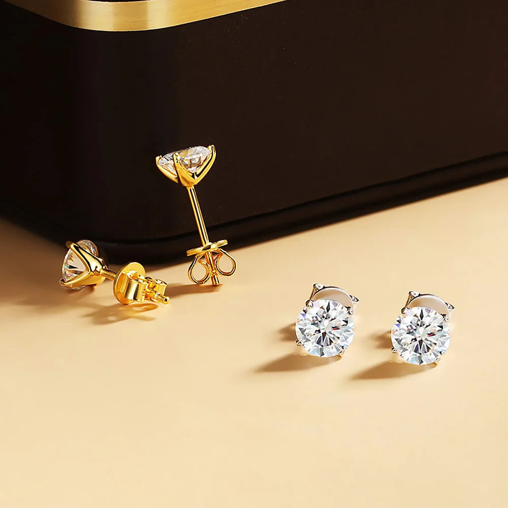 Boucles d’oreilles clou en zircon cubique serti or et argent, vue en gros plan sur fond beige