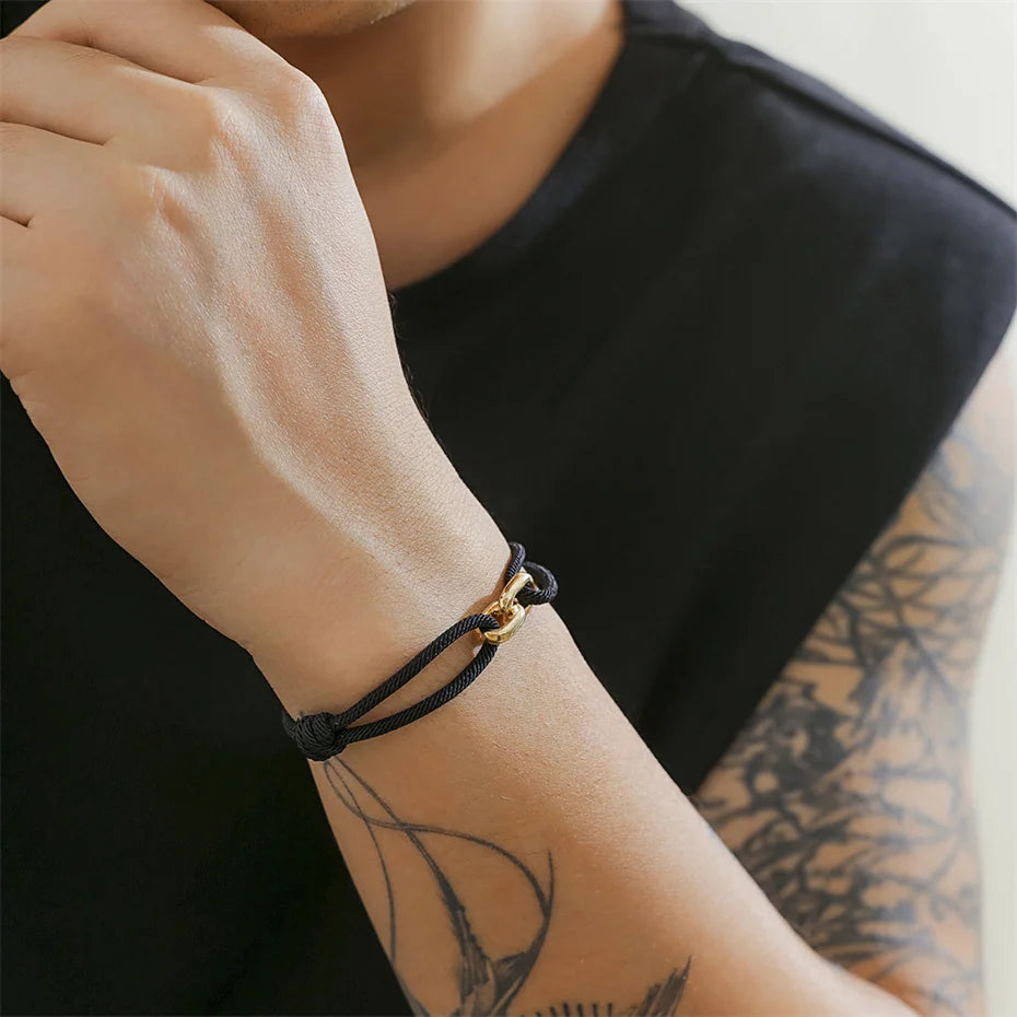 Bracelet noir au poignet avec look moderne.