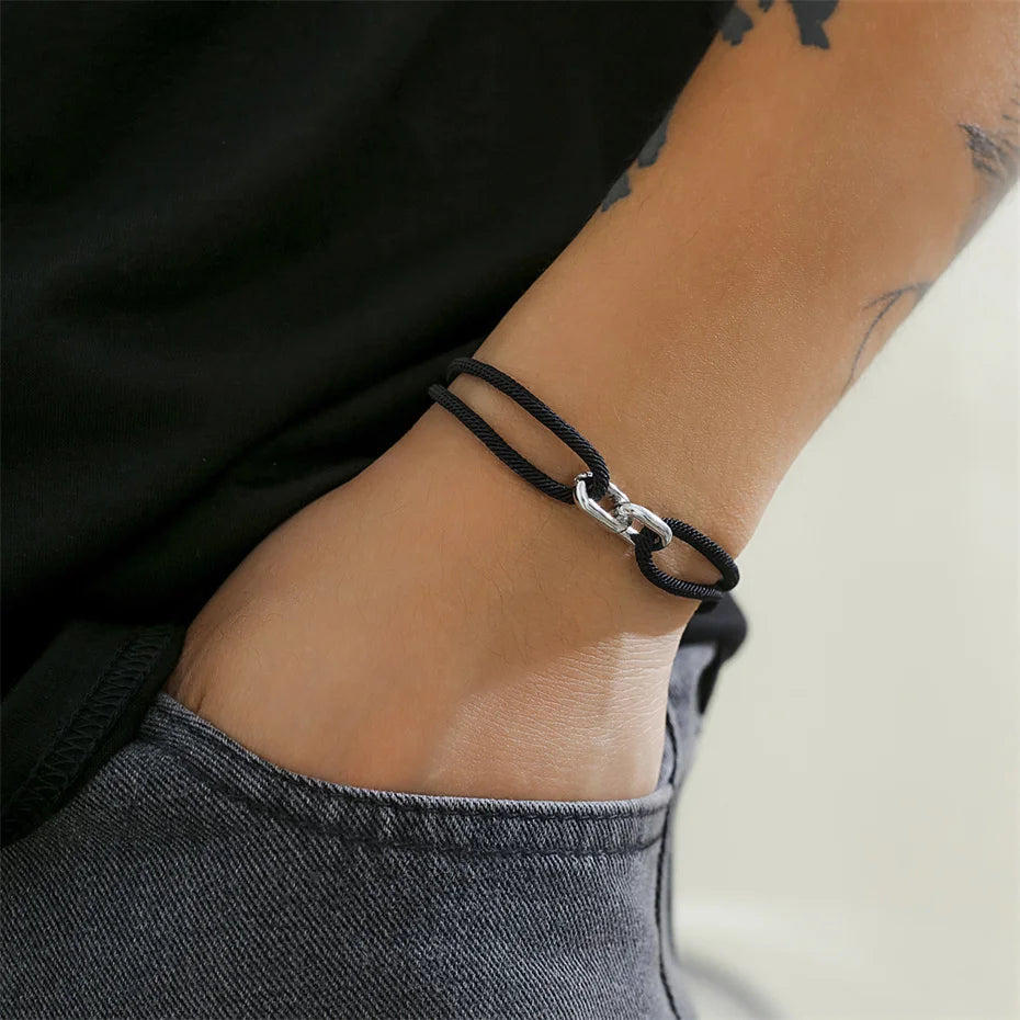 Bracelet noir porté par un homme, style casual.