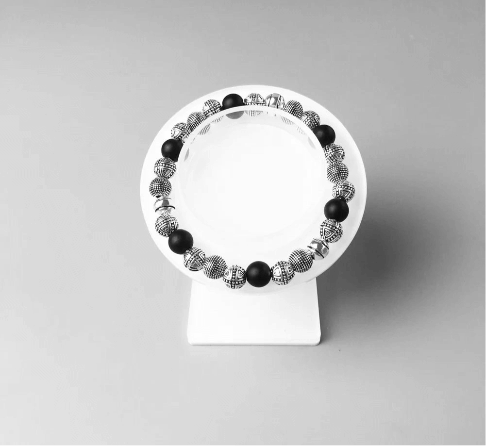 Bracelet perles noires et argent – présentation sur support bijou blanc