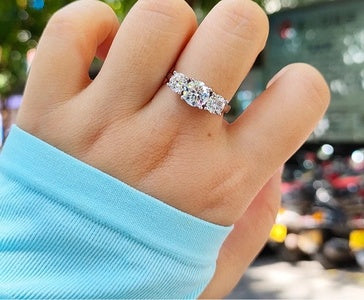 Bague en moissanite 1ct et 2x5mm en argent 925, trois pierres scintillantes tenue entre deux doigts
