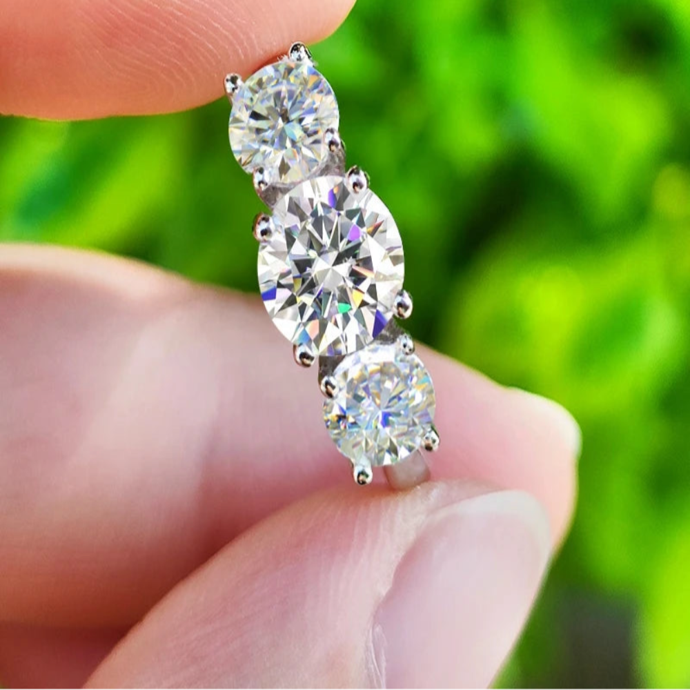 Bague en moissanite 1ct et 2x5mm en argent 925, trois pierres scintillantes tenue entre deux doigts