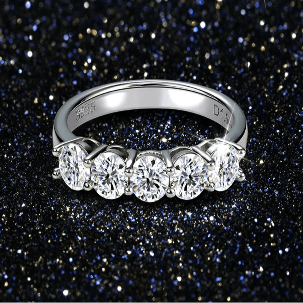 Bague en argent 925 avec cinq pierres brillantes, vue rapprochée sur fond noir scintillant