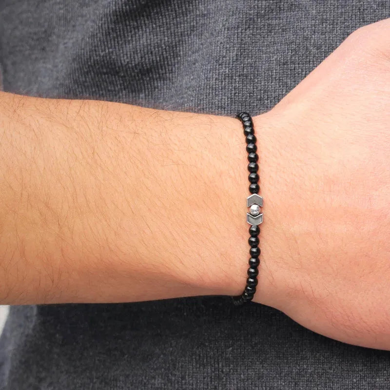 Bracelet homme croix perles noires minimaliste porté au poignet